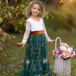 Toddler girl wearing white lace and hunter green flower girl dress