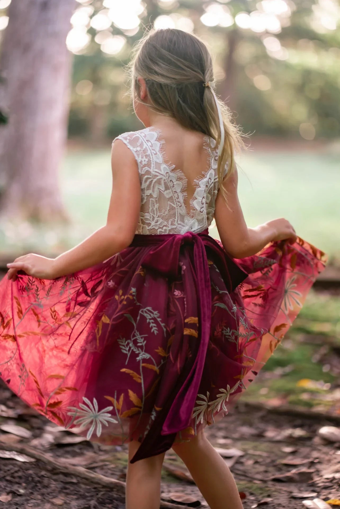 Close-up of knee-length burgundy tulle skirt with embroidered florals