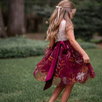 White lace and burgundy floral embroidered dress on little girl twirling