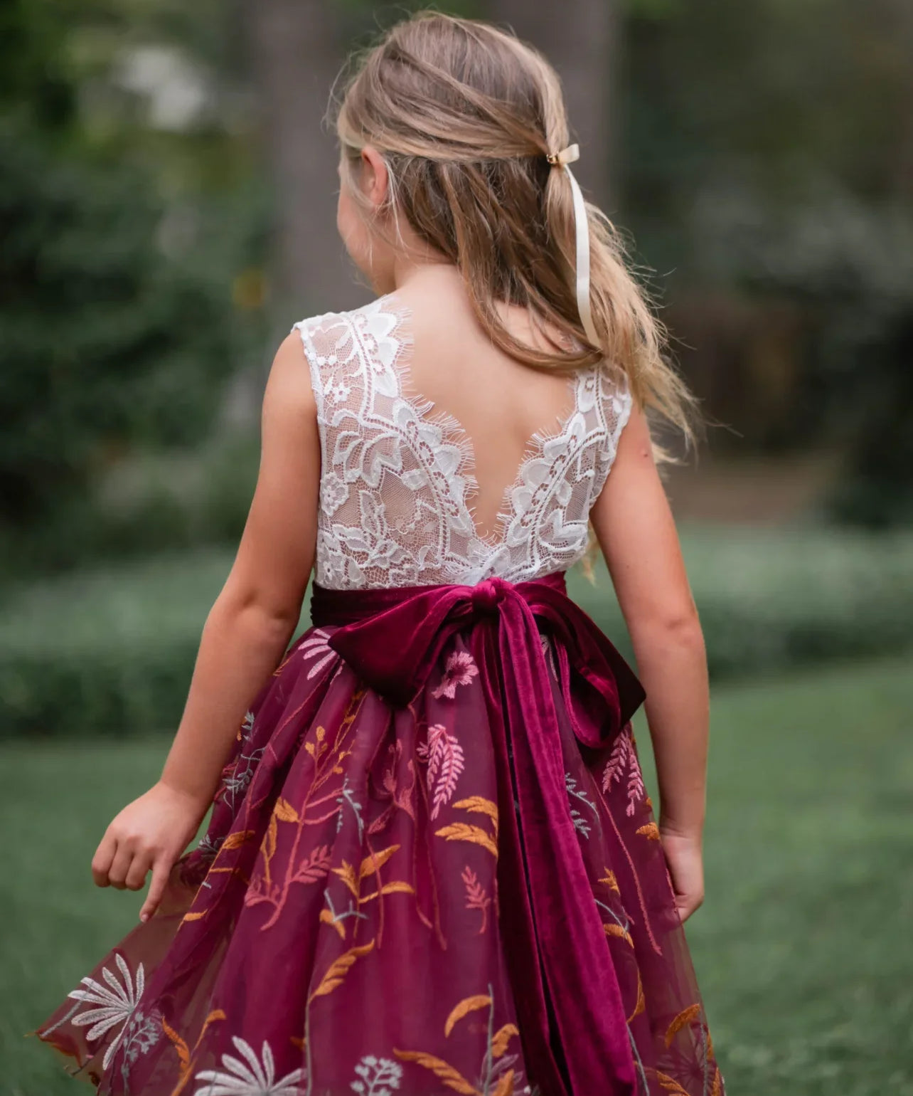 Back view of V-shaped lace back and burgundy velvet bow