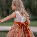 Detailed view of embroidered tulle skirt with fall florals and velvet sash on flower girl dress