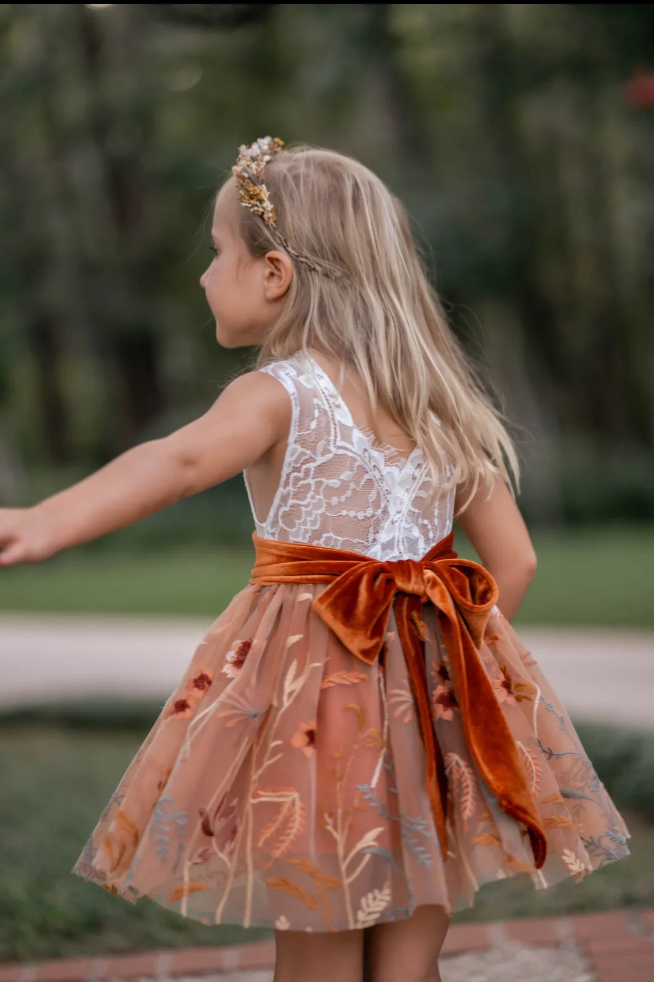Detailed view of embroidered tulle skirt with fall florals and velvet sash on flower girl dress