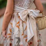 Close-up of champagne velvet sash on girls’ embroidered knee-length dress
