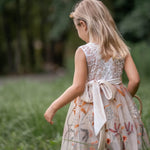 Back view of sleeveless flower girl dress with V-shaped lace and embroidered tulle