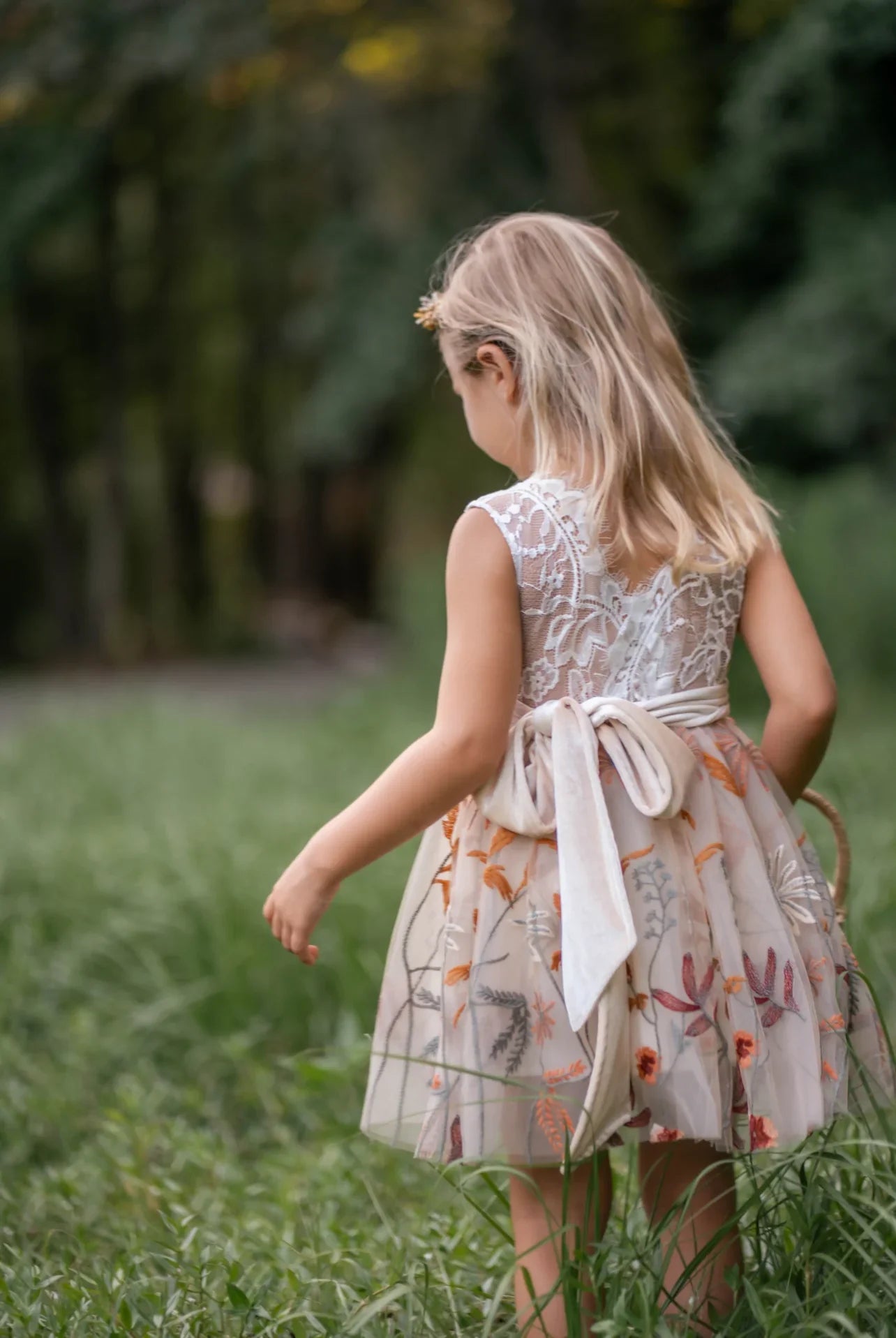 Back view of sleeveless flower girl dress with V-shaped lace and embroidered tulle
